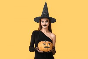 donna con cappello da strega e zucca Halloween