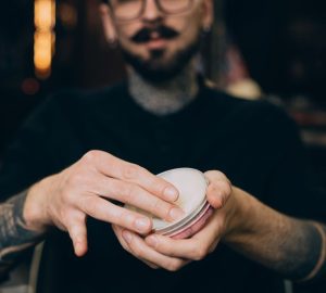 uomo con cera per capelli tra le mani