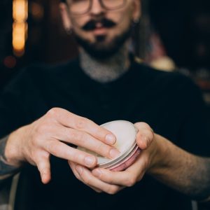 uomo con cera per capelli tra le mani