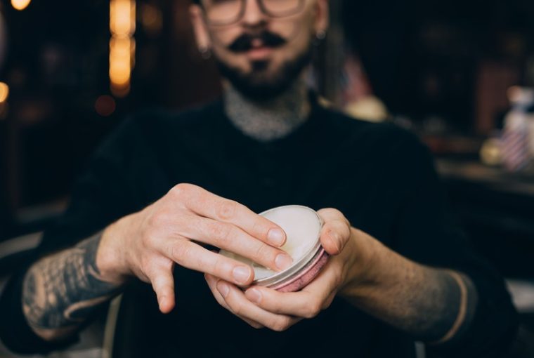 uomo con cera per capelli tra le mani