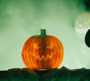 Halloween unisce Ognissanti, riti stagionali e cultura pop: Inquietante zucca di Halloween con un volto minaccioso avvolto…