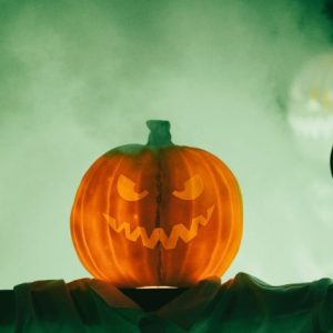 Halloween unisce Ognissanti, riti stagionali e cultura pop: Inquietante zucca di Halloween con un volto minaccioso avvolto…
